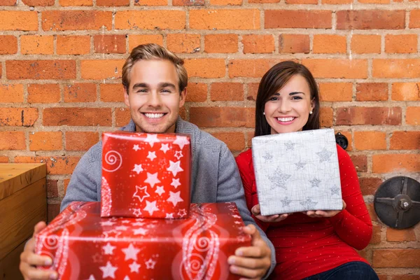 Met geschenken in hun appartement (echt) paar — Stockfoto