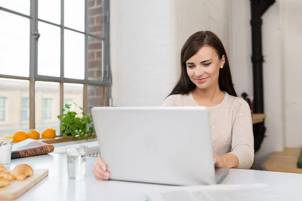 Woman at kitchen table with laptop — Stock Photo, Image