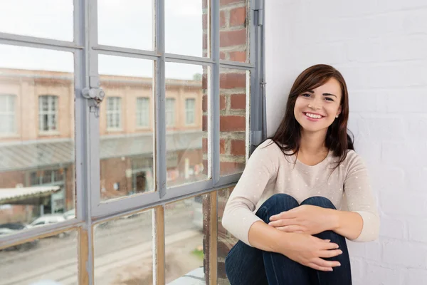 Donna seduta vicino alla finestra — Foto Stock