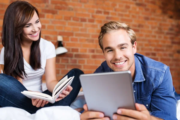 Couple with tablet and book at home — Stock Photo, Image