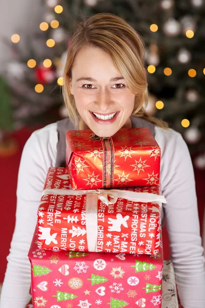 Femme riante portant pile de cadeaux — Photo