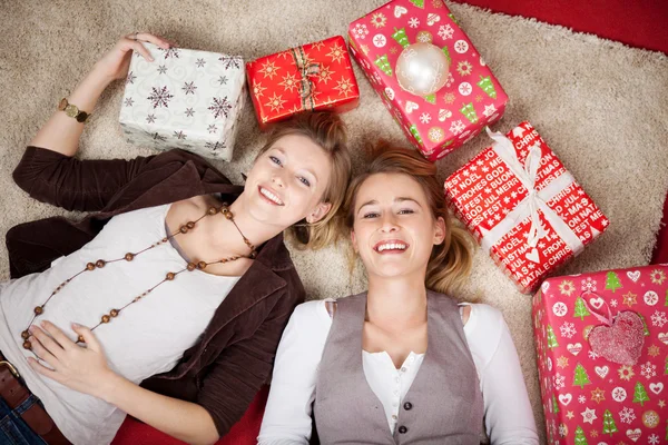Freunde liegen mit Weihnachtsgeschenken herum — Stockfoto