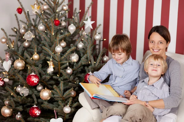 母亲和孩子们在圣诞树前 — 图库照片