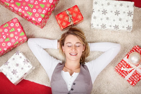 Frau mit Weihnachtsgeschenken umgeben — Stockfoto