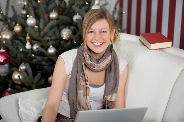 Vrouw met laptop in de buurt van de kerstboom — Stockfoto