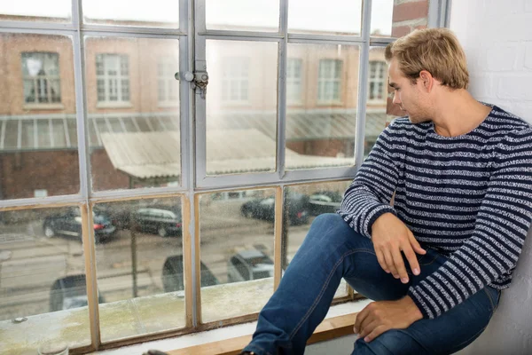 Man sitting looking out of window — Stock Photo, Image