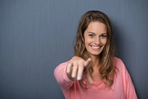 Lächelnde Frau zeigt in die Kamera — Stockfoto