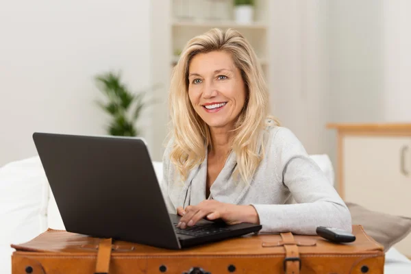 Frau kommuniziert mit Laptop nach Hause — Stockfoto