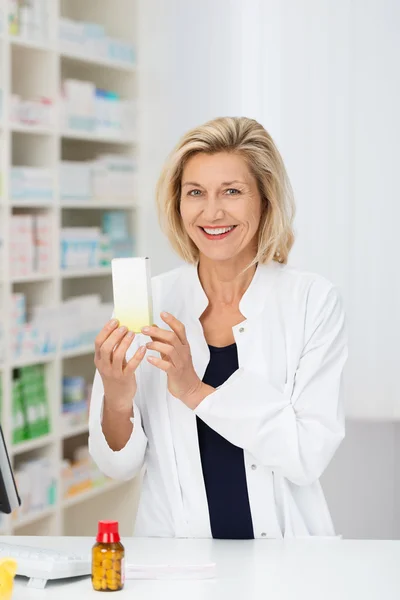 Pharmacist displaying promotional product — Stock Photo, Image