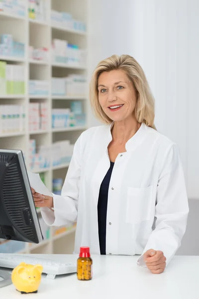 Farmacêutico fêmea segurando prescrição — Fotografia de Stock