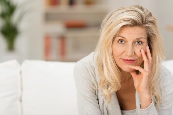 Nachdenkliche Frau sitzt auf Couch — Stockfoto