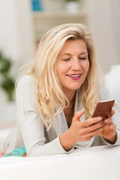 Frau mittleren Alters liest SMS — Stockfoto