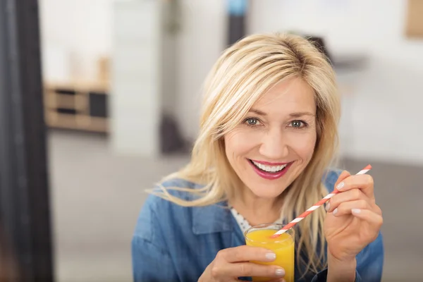 Счастливая женщина пьет апельсиновый сок — стоковое фото