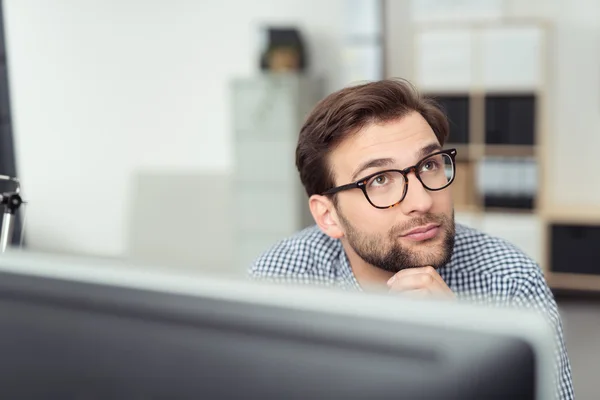 Empresário usando óculos sentado pensando — Fotografia de Stock