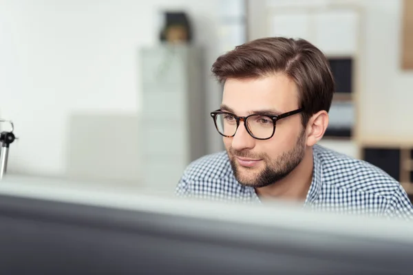 Бізнесмен на своєму столі обличчям до екрану комп'ютера — стокове фото