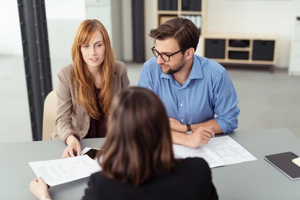 Young couple discussing investments with a broker — Stock Photo, Image