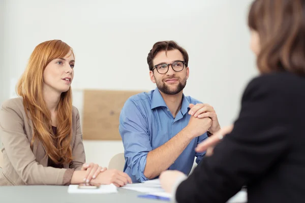 Makelaar een discussie met een jong koppel — Stockfoto