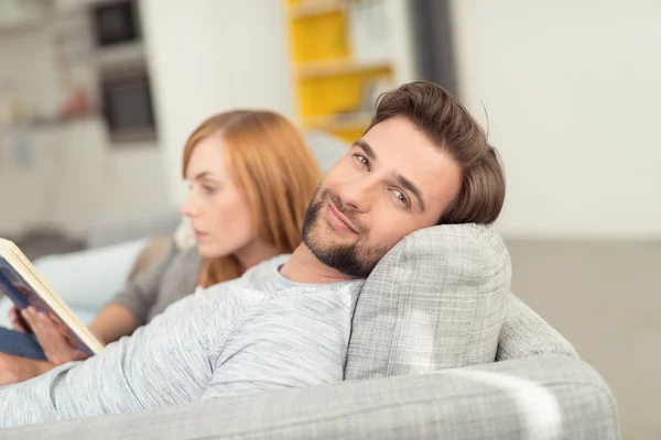 Портрет мужчины, расслабляющегося с женщиной на диване — стоковое фото