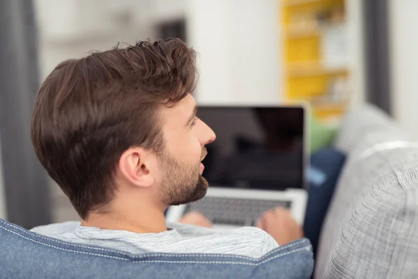 Fiatal férfi bágyasztó-on dívány laptop — Stock Fotó