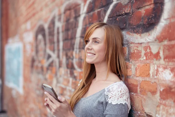 Mujer bonita feliz sosteniendo un móvil — Foto de Stock