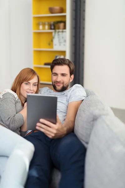 Joven hombre y mujer leyendo una tableta PC — Foto de Stock