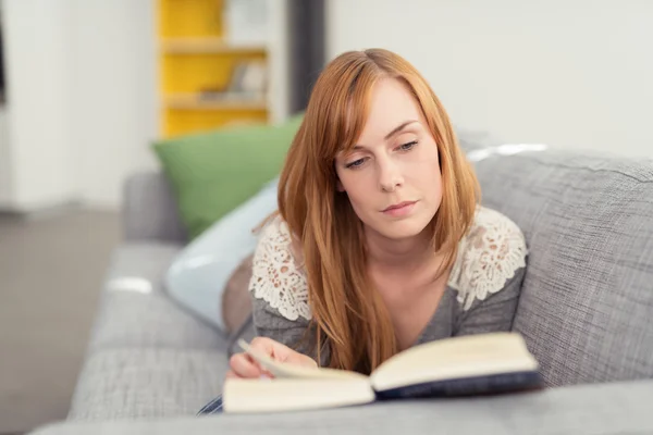 Ung kvinna läser en bok — Stockfoto