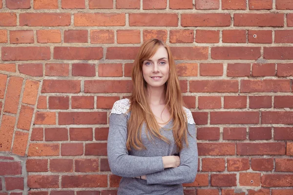 Woman Against Brick Wall with Arms Crossed — Zdjęcie stockowe