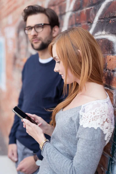 Mujer ocupada con el teléfono al lado de su novio —  Fotos de Stock