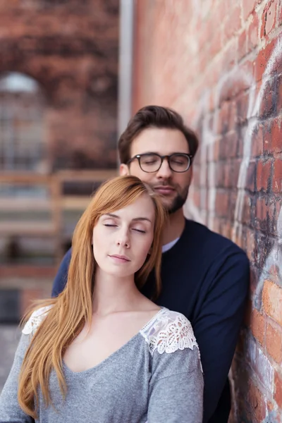 Thoughtful Couple Standing Beside Brick Wall — Zdjęcie stockowe