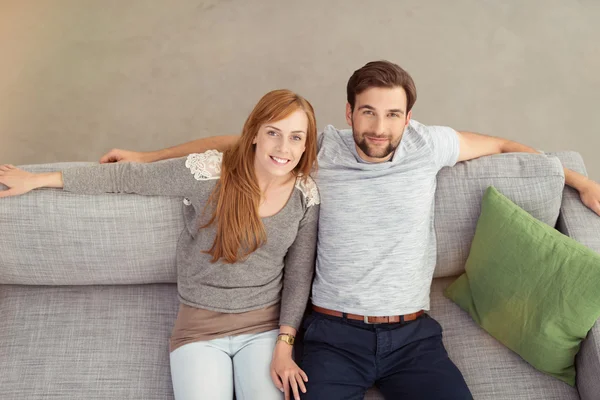 Dulce joven pareja en sofá —  Fotos de Stock