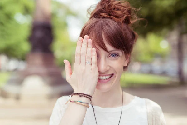 Woman holding her hand to her eye — Stock Photo, Image