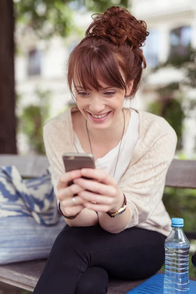 Mujer joven leyendo un mensaje de texto — Foto de Stock