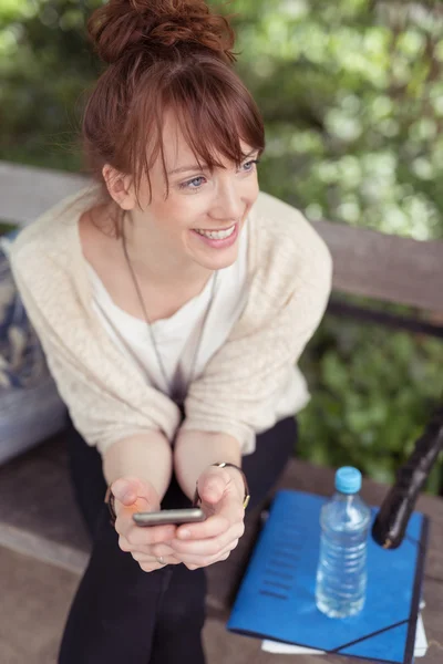Pleased young woman sitting watching something — Stock Photo, Image