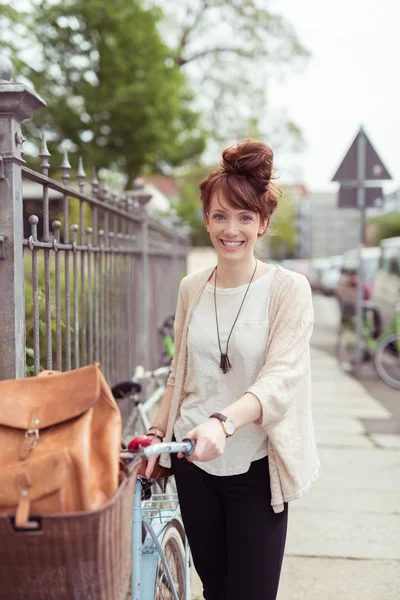 Pretty stylish woman with her bicycle — Stok fotoğraf
