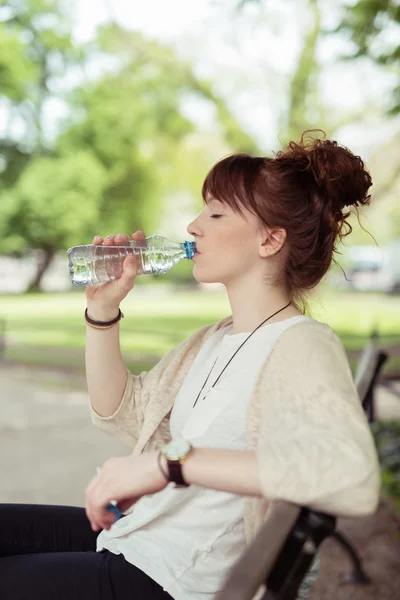 Pretty Woman Sitting at the Bench Drinking Water — Zdjęcie stockowe