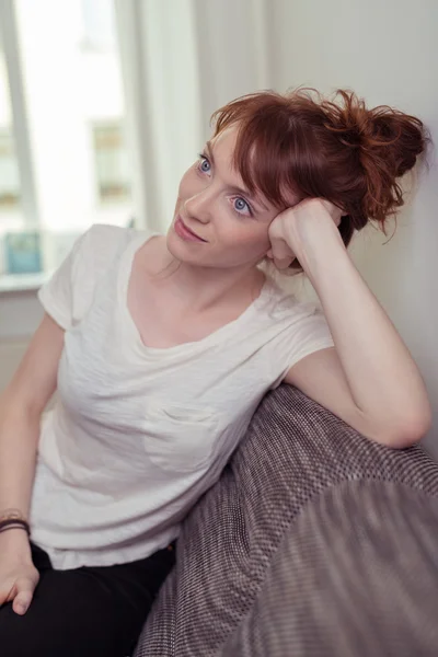 Thoughtful Girl Leaning on her Elbow at the Couch — Stock Photo, Image