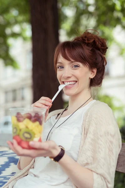 Happy woman eating fresh fruit salad — Stock Photo, Image