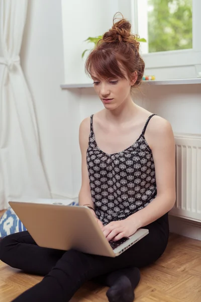 Jeune femme se détendre à la maison avec un ordinateur portable — Photo