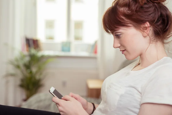 Junge Frau liest eine SMS — Stockfoto