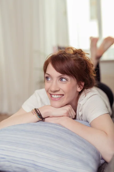 Cheerful Young Woman on Sofa Looking Into Distance — Stock Photo, Image