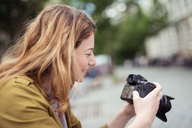 Happy Girl Looking at her Captured Photos on DSLR clipart