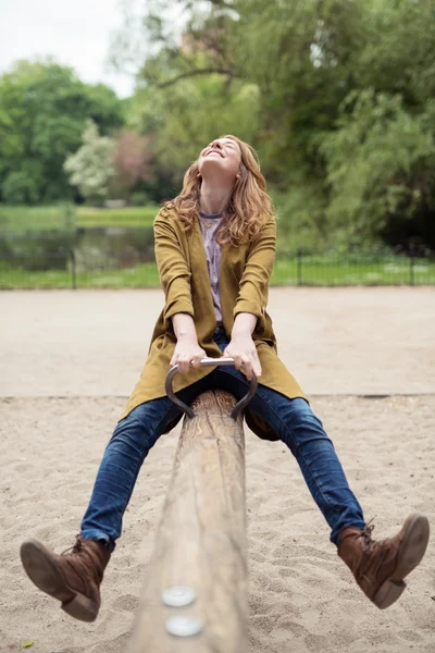 Feliz teen menina jogar seesaw no o parque — Fotografia de Stock