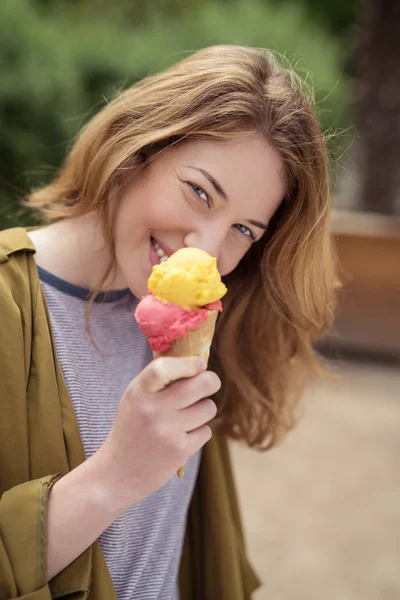 Lächelndes Teenie-Mädchen isst Eis auf einem Kegel — Stockfoto