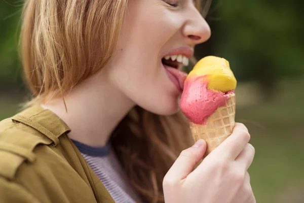 Blond tonåring tjej slickar glass på en kon — Stockfoto