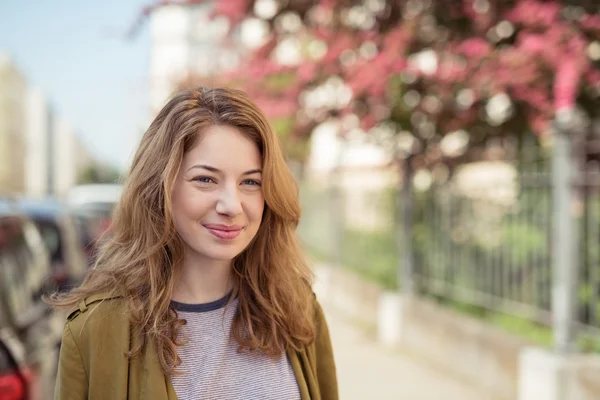 Garota sorridente na rua olhando para a distância — Fotografia de Stock