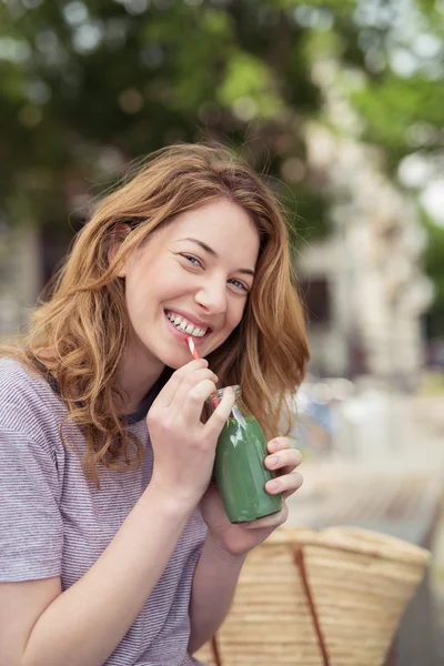 Jolie fille buvant du jus, regardant la caméra — Photo