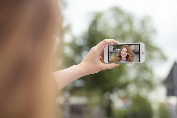 Hand som håller mobiltelefon samtidigt som selfie — Stockfoto