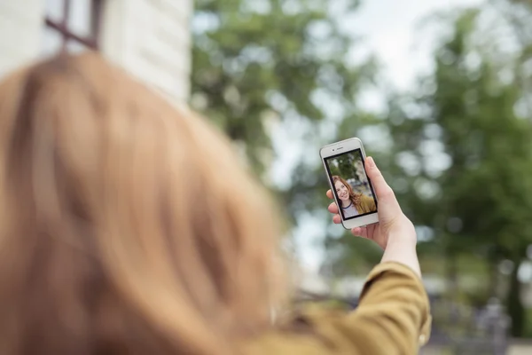 Ragazza adolescente che tiene il telefono mentre prende foto selfie — Foto Stock