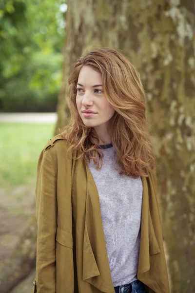 Bastante rubia adolescente chica en frente un Grande árbol tronco — Foto de Stock