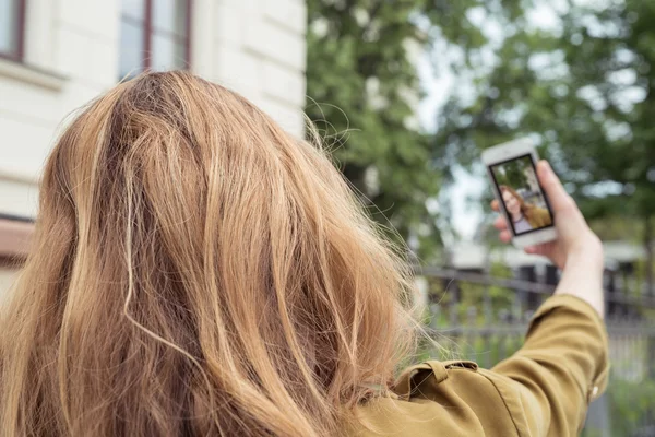 Blond tonåring tjej tar själv foto med telefonen — Stockfoto